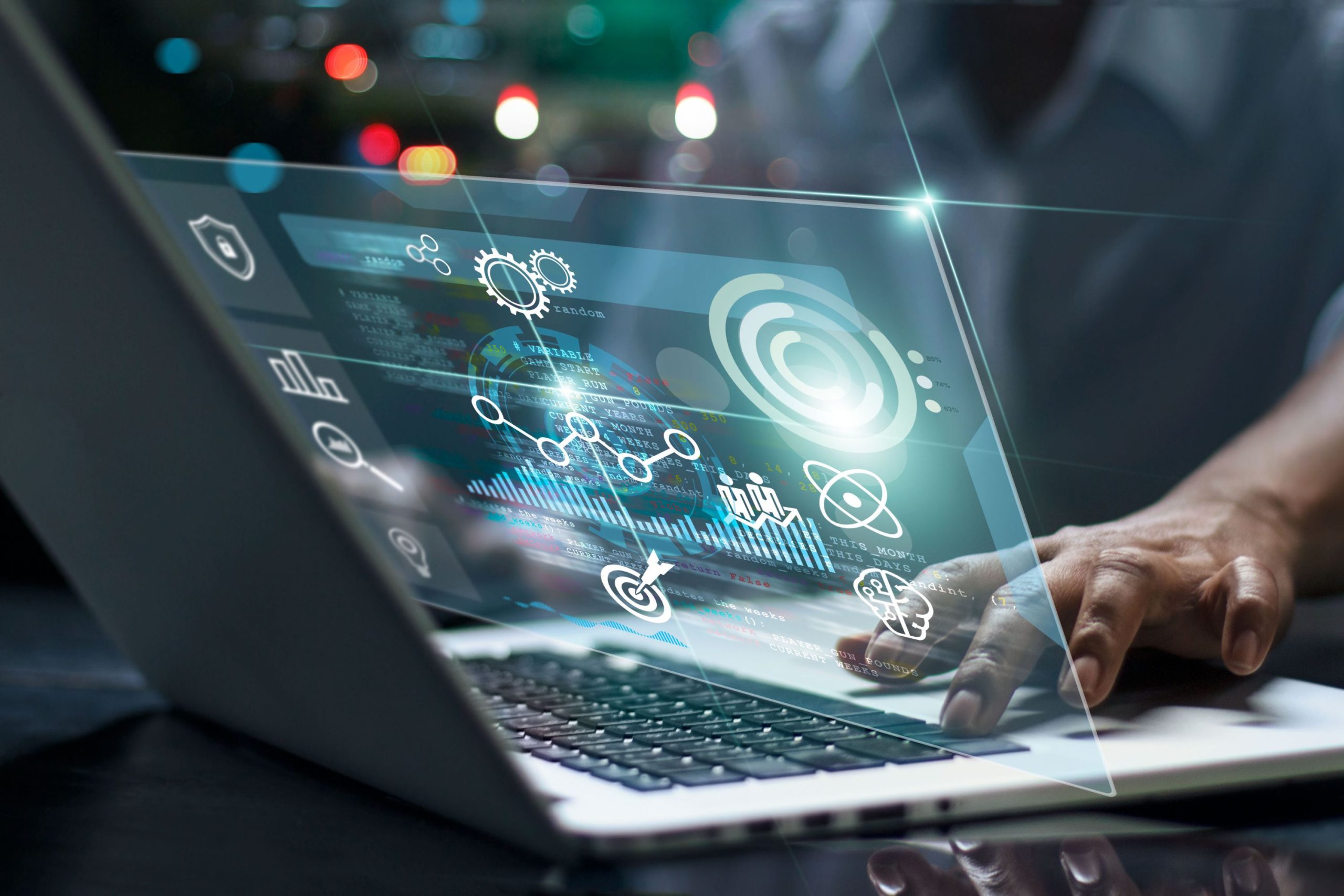 Nad laptopem unoszą się cyfrowe wykresy